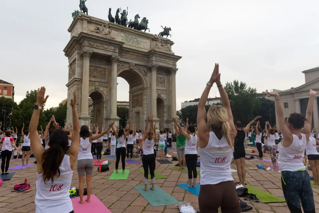 Insegnante di yoga guida la sequenza dei Saluti al Sole in un evento del 2022